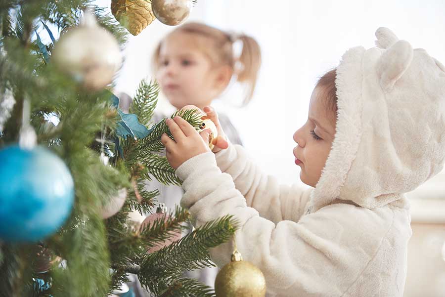 Portrait of happy girl decorating Christmas tree.